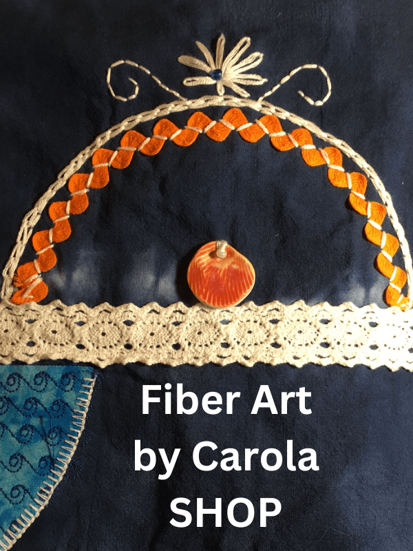 Graphic logo with text,"Fiber Art by Carola" on indigo dyed cloth with embroidery, rickrack and crochet lace